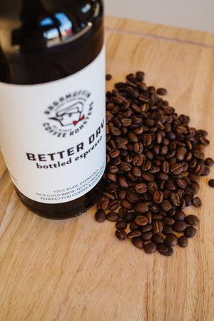 On the counter a bottle of Better Day Bottled Espresso with coffee beans from Ragamuffin Coffee