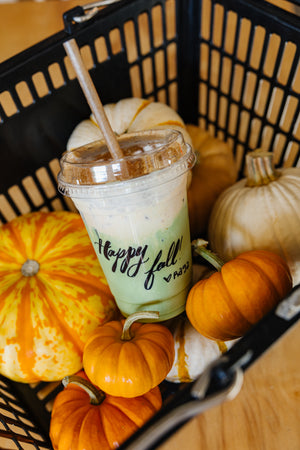 Happy Fall iced pumpkin matcha in a basket of pumpkins at Ragamuffin Coffee
