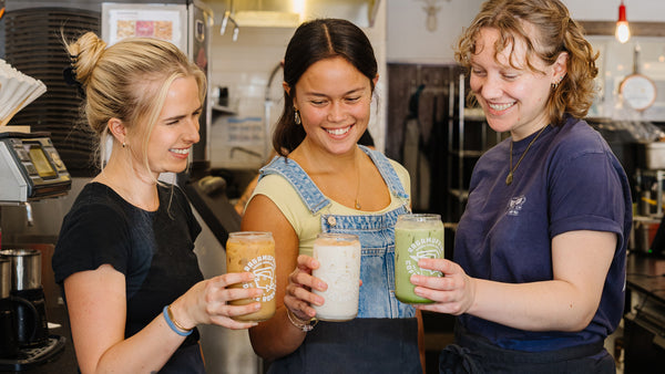 Ragamuffin Coffee Roasters team sharing smiles and iced drinks — better coffee, better day.